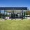 modern glass house with green lawn and blue sky 2026 03 09 03 26 48 utc
